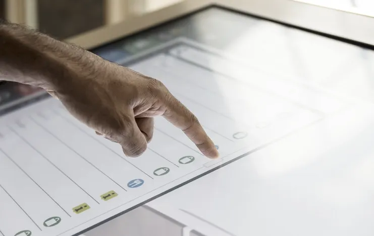 Close-up of a hand interacting with a touchscreen interface, highlighting Trinergy's advanced interactive technology solutions.