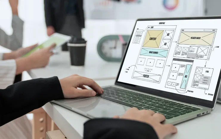 A website wireframe design displayed on a laptop, showing Trinergy's digital development planning process.