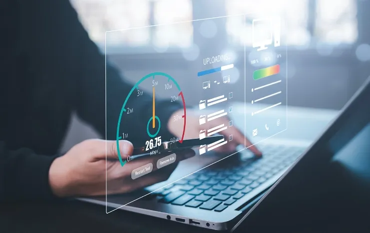 Close-up of a user analyzing performance metrics on a laptop and smartphone with interactive digital dashboards, powered by Trinergy solutions.