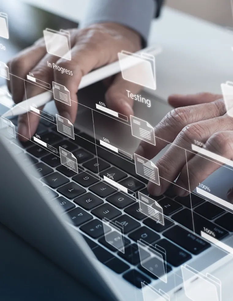 Hands typing on a laptop keyboard with digital project management visuals, including progress and testing indicators, representing Trinergy's efficient project workflow solutions.